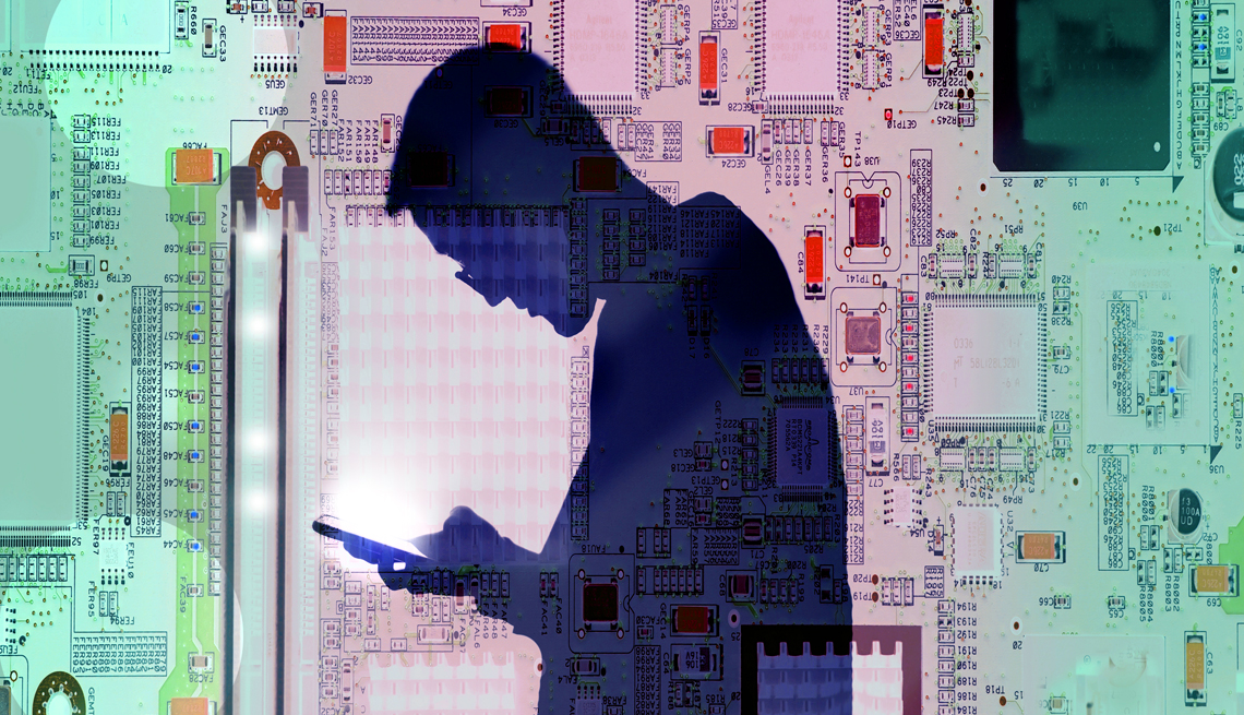 the silhouette of a man looking into a glowing smart phone