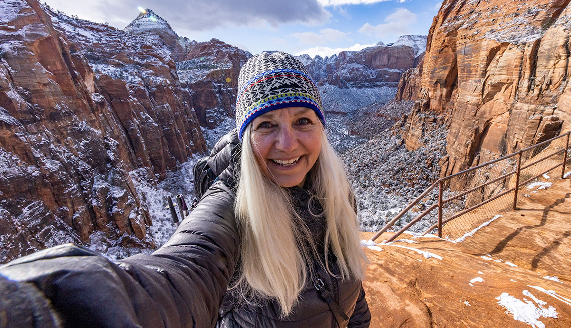 Mujer se toma un selfie en una montaña rocosa