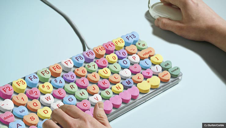 Man typing on computer keyboard candy hearts, Online Dating 