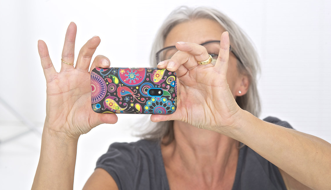 Mujer mayor tomandose una foto con su teléfono móvil