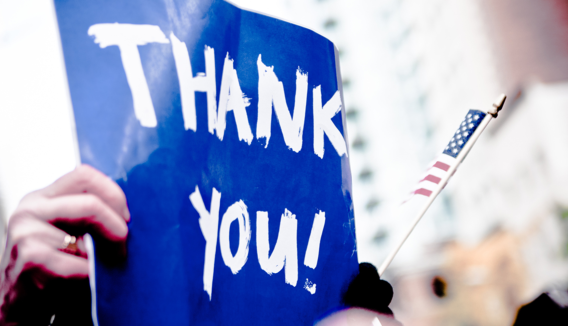 a blue sign that says thank you with a small american flag next to it