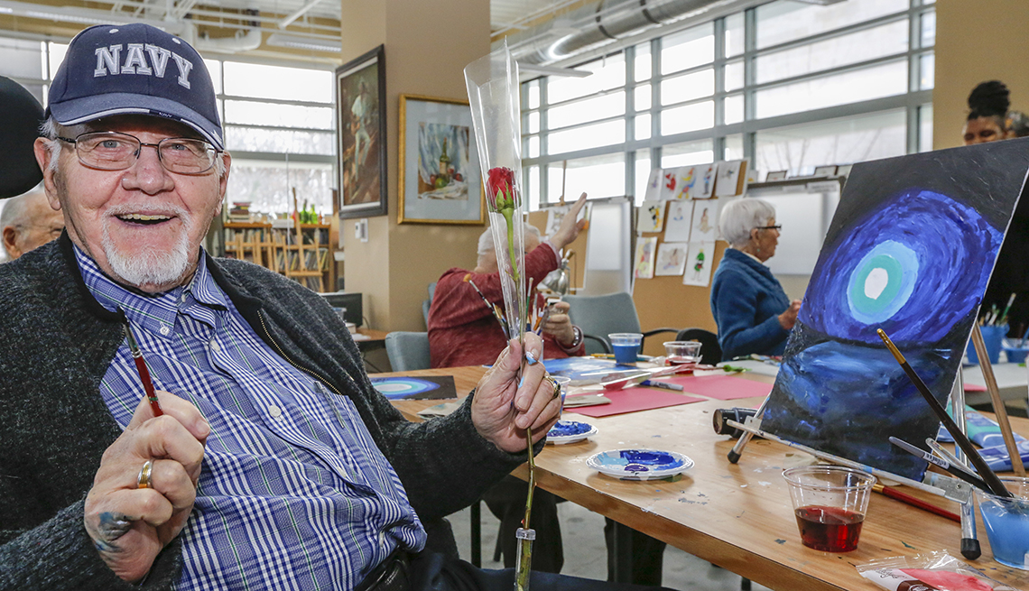 Man in a Veterans home art class holds a rose