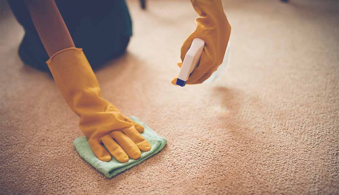 Errores que cometemos al limpiar y cómo evitarlos - Persona limpiando una alfombra