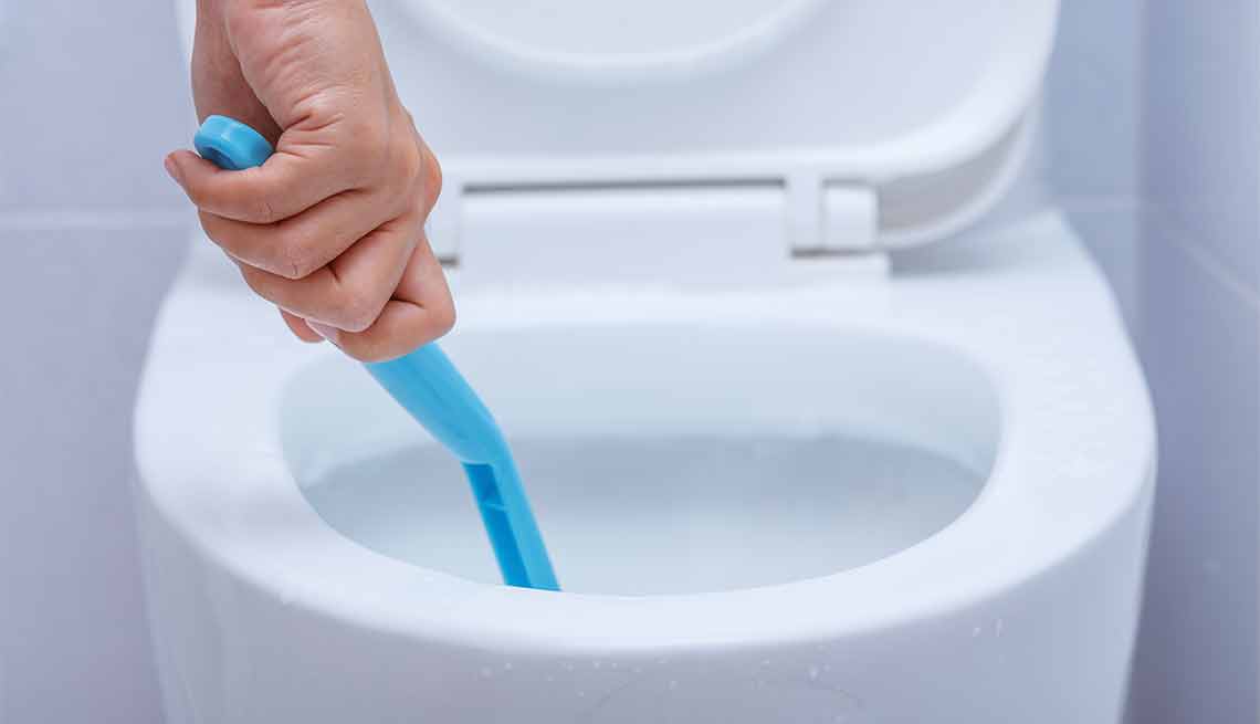 Errores que cometemos al limpiar y cómo evitarlos - Persona limpia un baño sin guantes