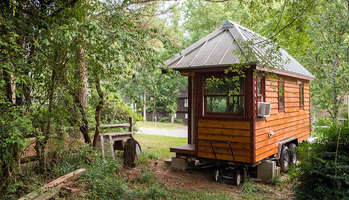 A tiny home on wheels in a wooded area