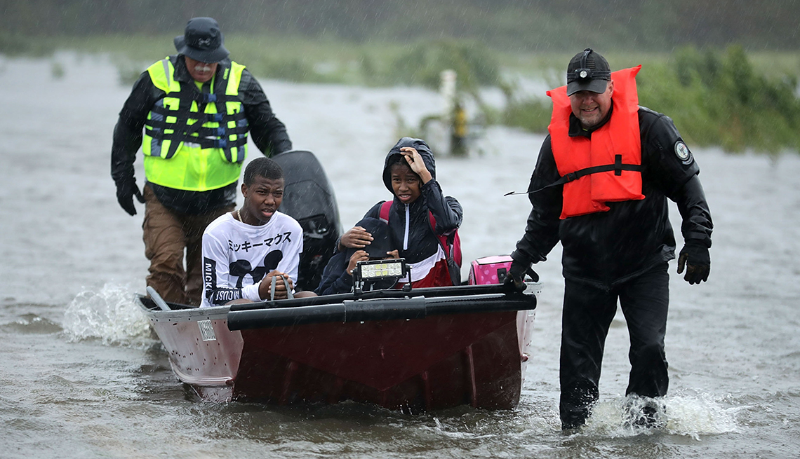 Three children in a boat are rescued by volunteers during Hurricane Florence