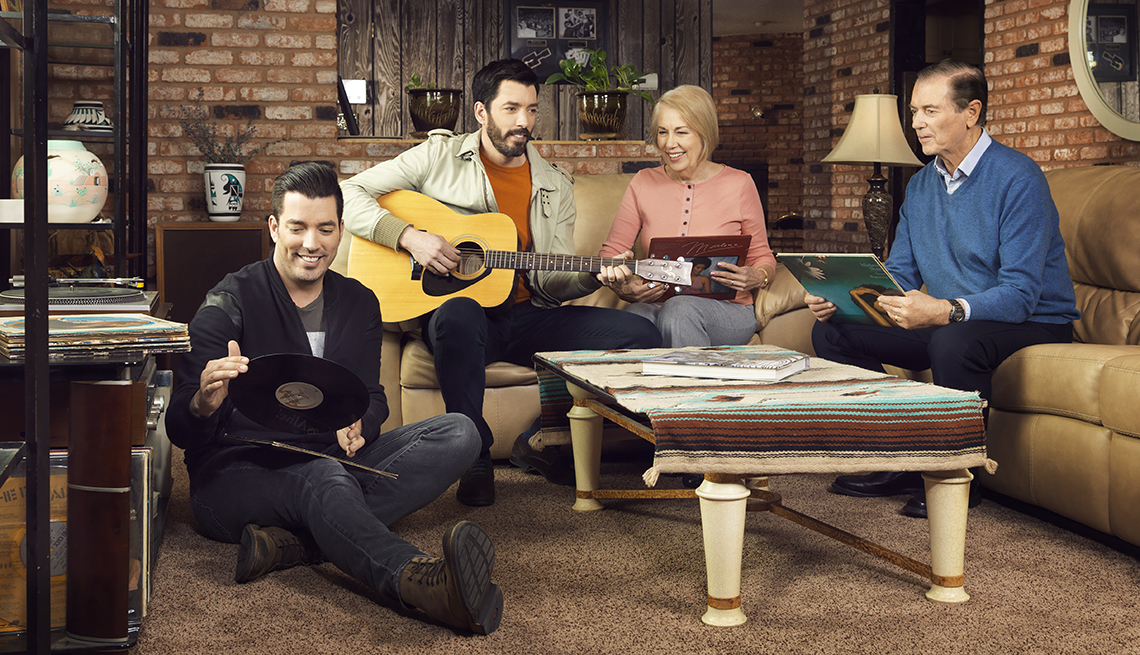 Jonathan and Drew Scott with their parents sitting around a table