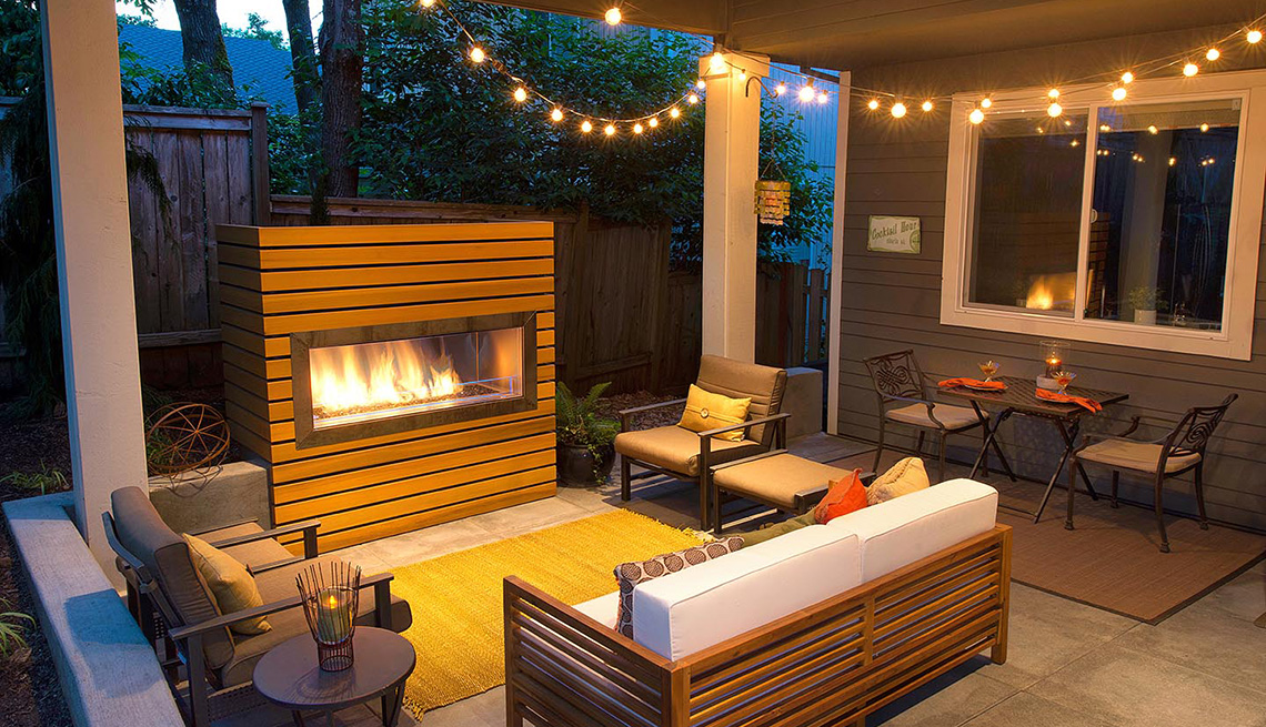 An outdoor patio with a fireplace and outdoor lighting