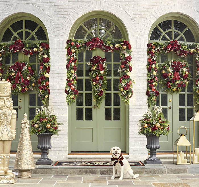 item 1 of Gallery image - Front door decorated in garland, with a dog smiling
