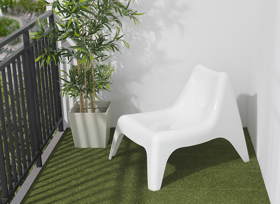 Una silla blanca sobre una grama sintética en un balcón