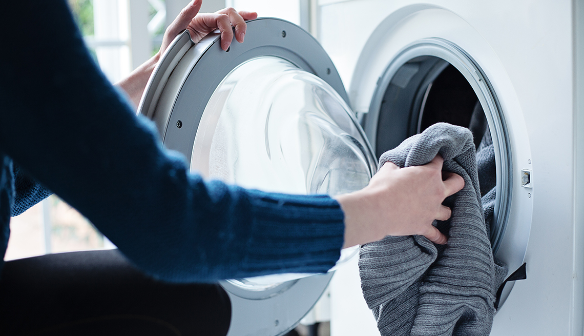 Mujer pone ropa dentro de la lavadora
