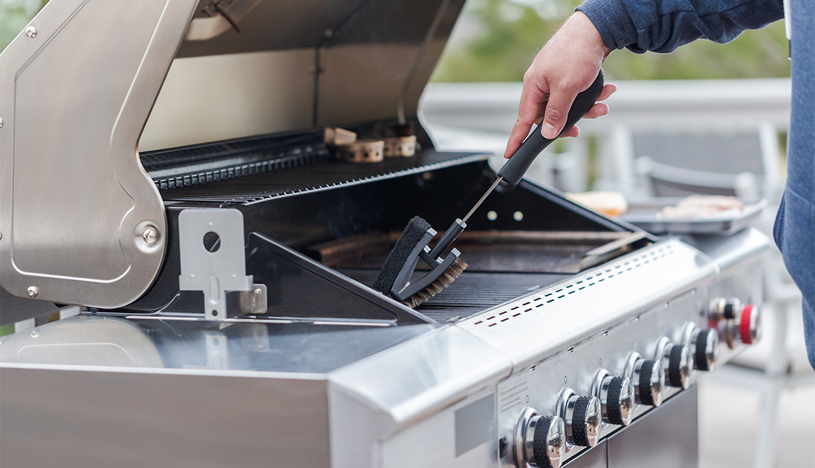 man cleaning grill