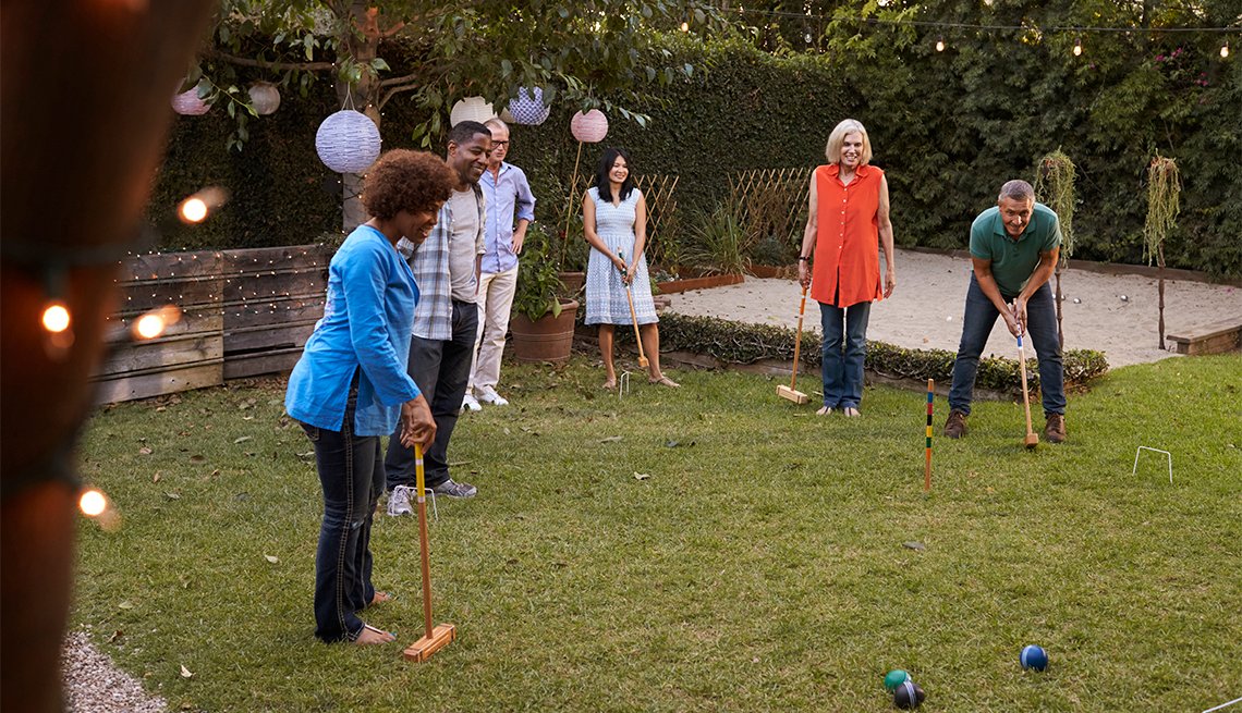 friends playing croquet in backyard