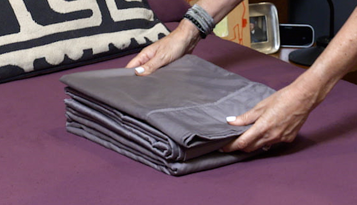 item 7 of Gallery image - placing pillowcases and top sheet above folded fitted sheet