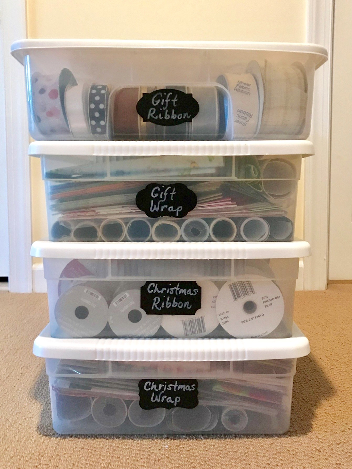 gift wrap supplies are organized in clear plastic storage bins