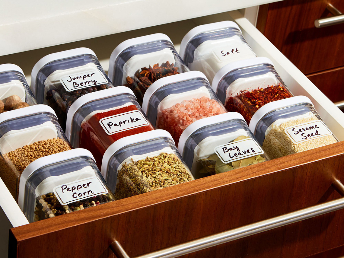clear jars of labeled spices arranged neatly in a drawer