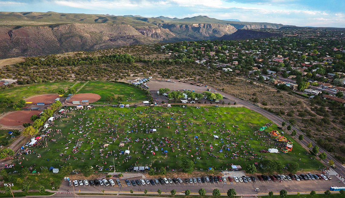item 8 of Gallery image - overhead view of a town event in a community athletic field in white work new mexico with a canyon in the background