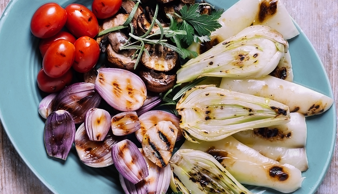 platter of grilled leeks onions mushrooms and grape tomatoes