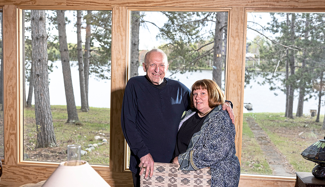 chris and kathleen rewey in their new home with a view of the lake through the windows behind them