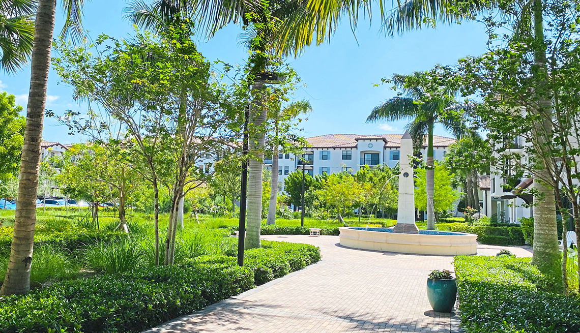 wide shot of an upscale apartment building and palm tree filled grounds in delray beach florida