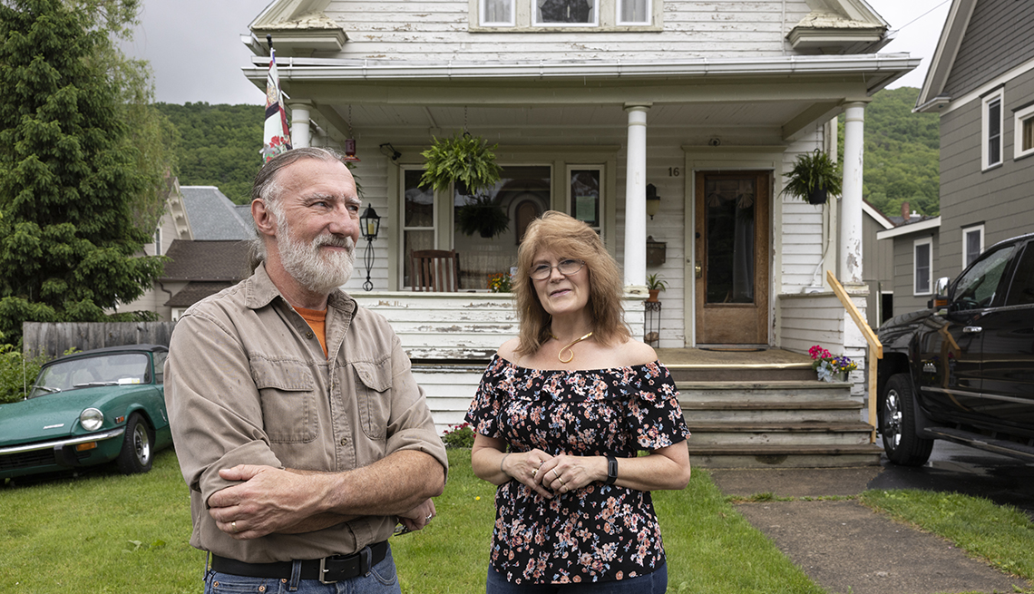 quinn and vivian golden stand in front of their new cottage home in dansville new york