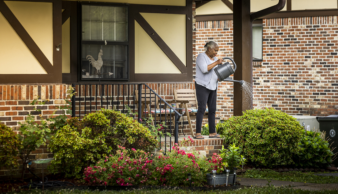 donna deans watering plants on the porch of her new home in oglethorpe georgia
