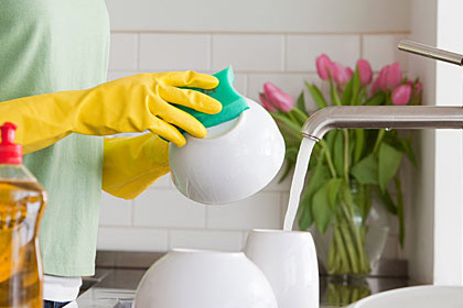 Limpie los gérmenes de su casa: Una mujer lavando la loza