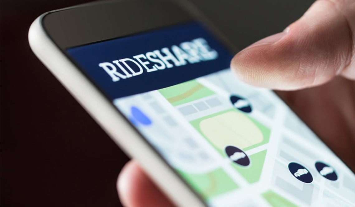 A smartphone user checks a rideshare app