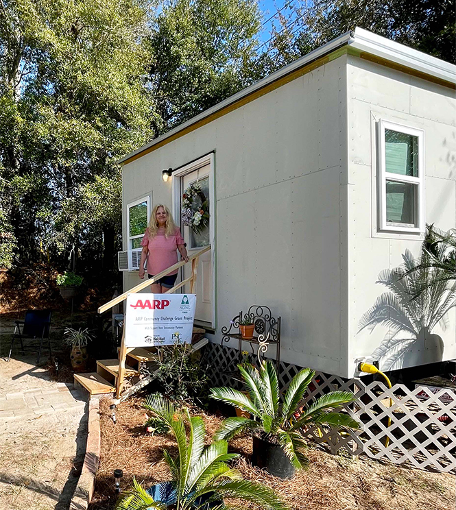 A resident in front of her new tiny house