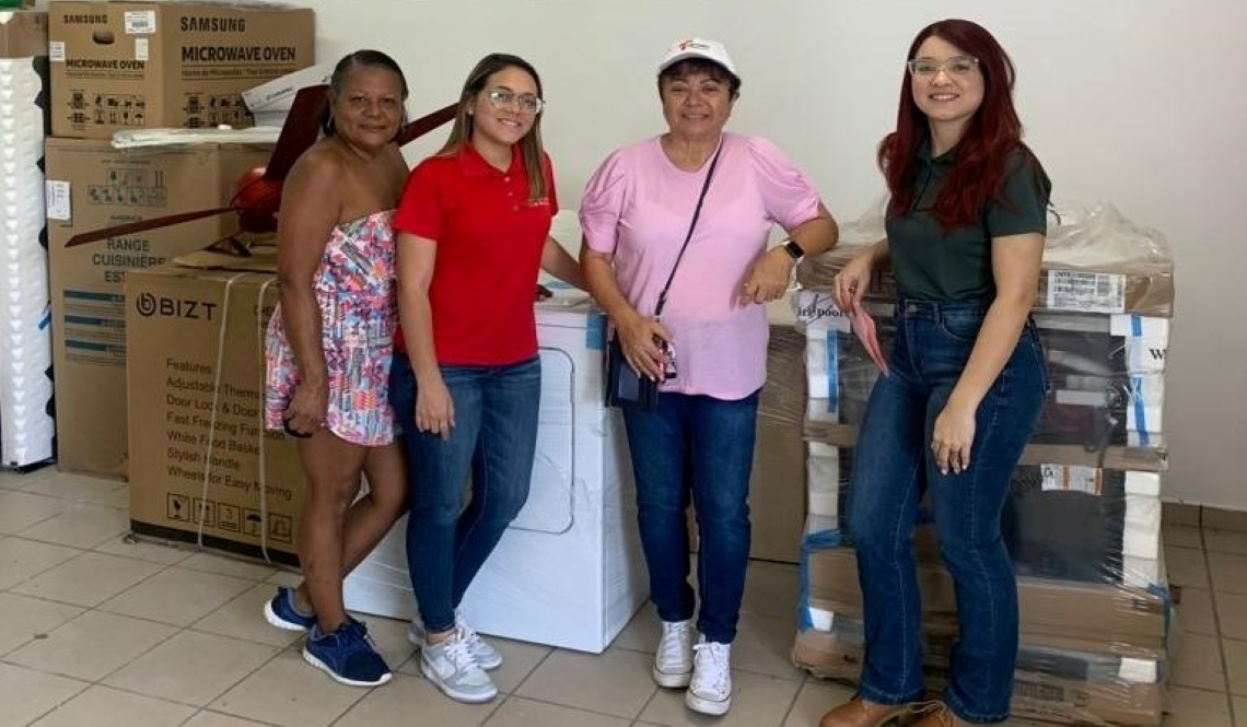 Four women pose bin front of donated appliances
