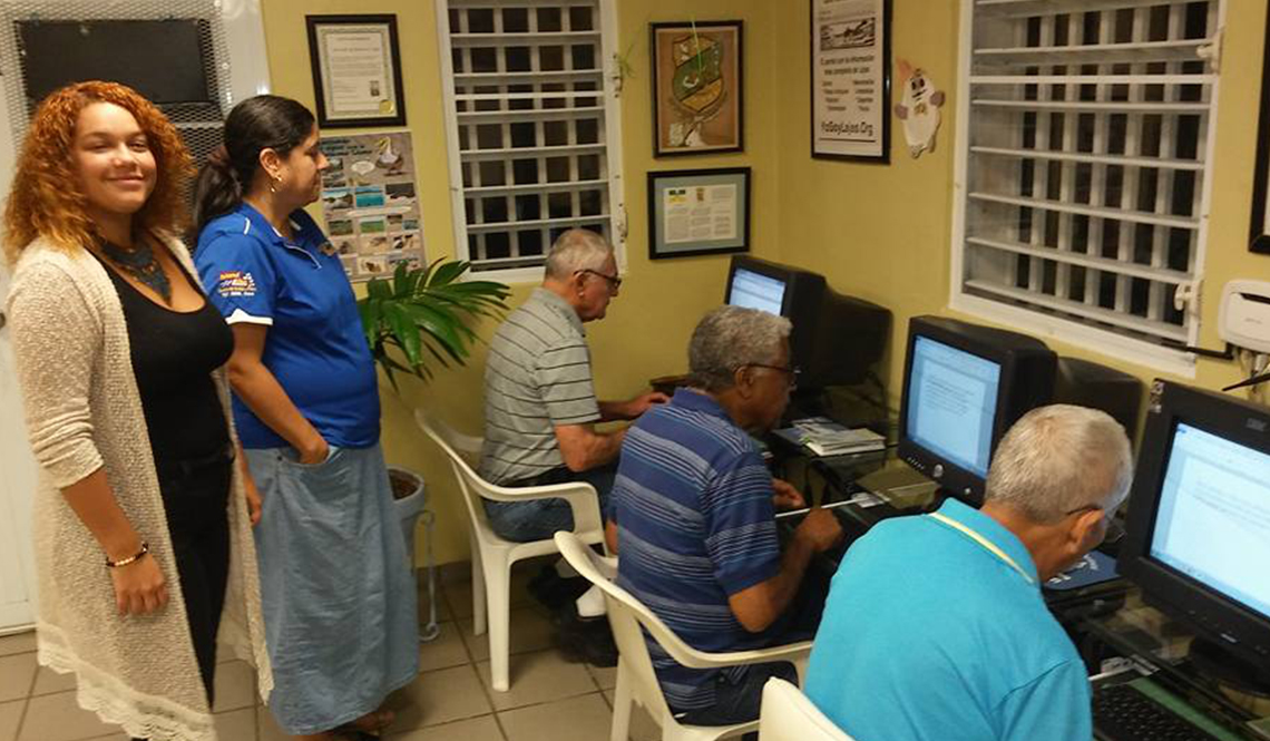 item 2 of Gallery image - Three older men work at computers in a Lajas, Puerto Rico, community center