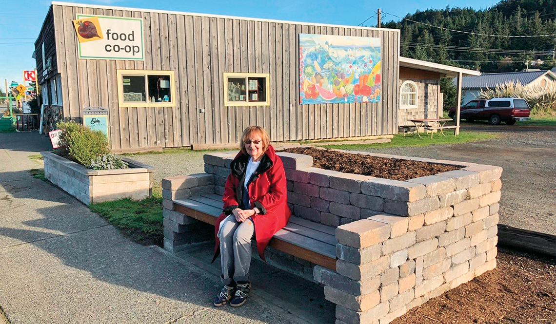 A resident of Port Orford, Oregon, sits on a stone bench created with funding from the AARP Community Challenge