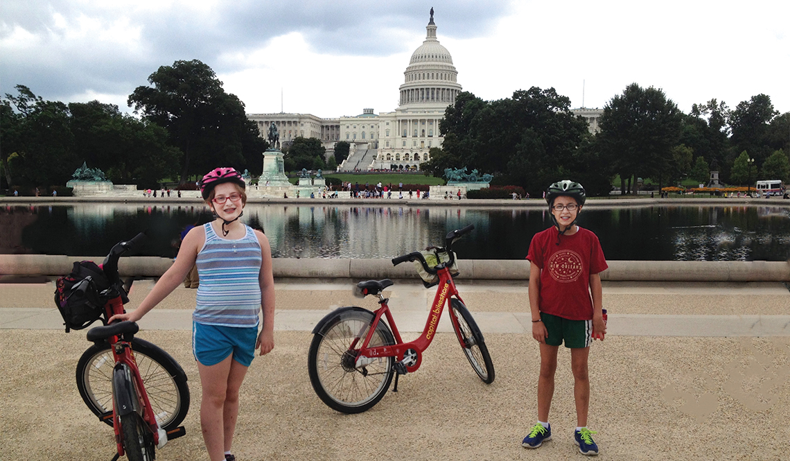 Two young girls pose next to Capital Bikeshare bicycles with the U.S. Capitol Building in the background