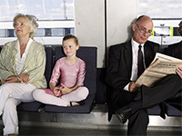 An older woman, young girl and older man ride public transportation.