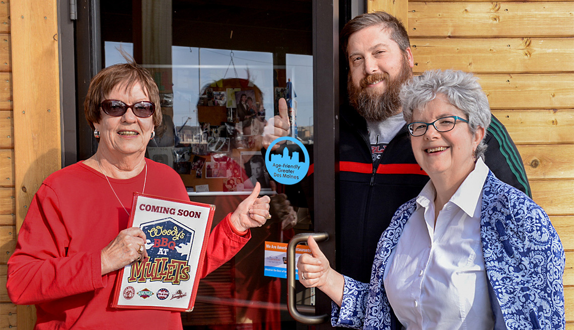 Two women and a man give a thumbs up to Mullets Restaurant in Des Moines being an Age-Friendly Business