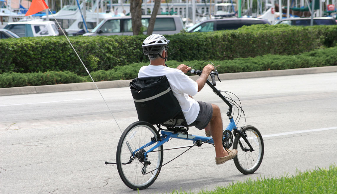 Hombre pedalea en un triciclo reclinable