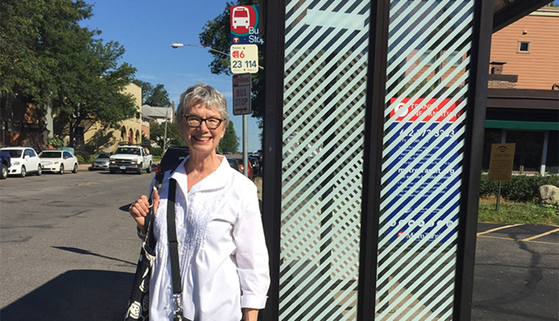 An Older Woman Smiles And Poses In Front Of A Bus Stop, Livable Communities, Why Older Adults Should Go Car-Free