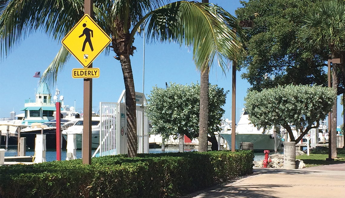 A crosswalk sign that says Elderly on it, as seen at a dock in Miami Beach