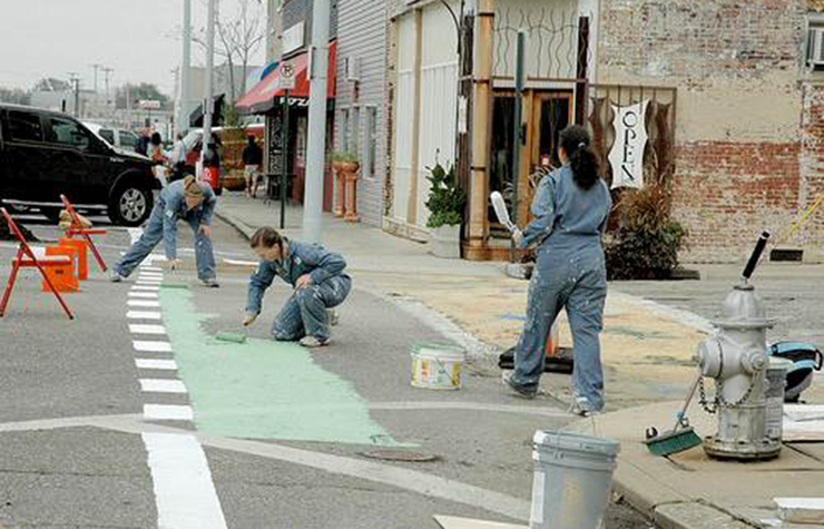 Painting a green bicycle lane for a pop-up demonstration on Broad Street in Memphis, Tennessee