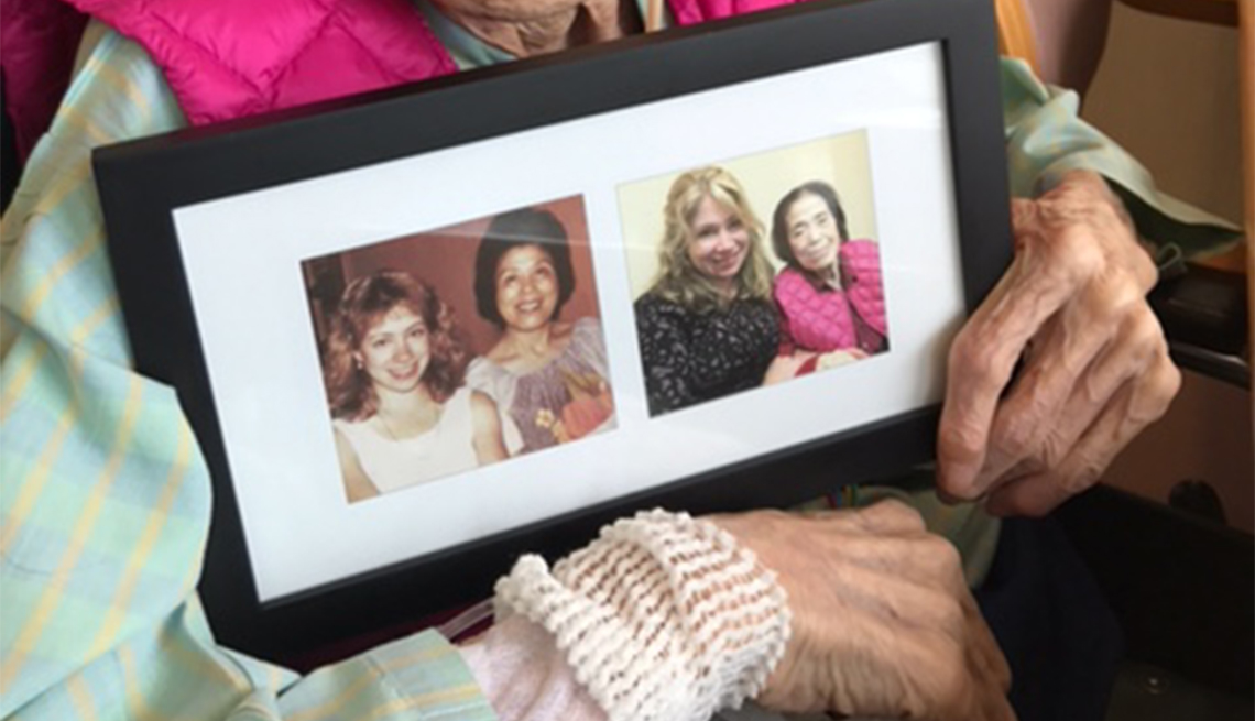 The author's Japanese mom holds a picture frame with snapshots of her and the author from the past and present.