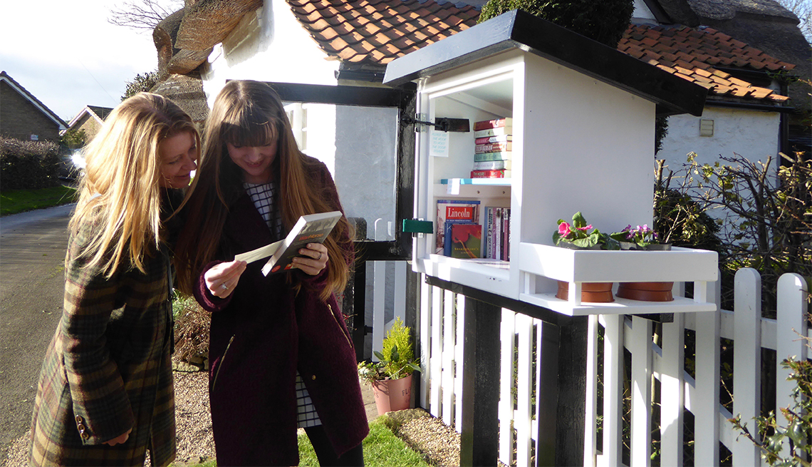 Two women look at books at a Little Free Library in Appleby, United Kingdom