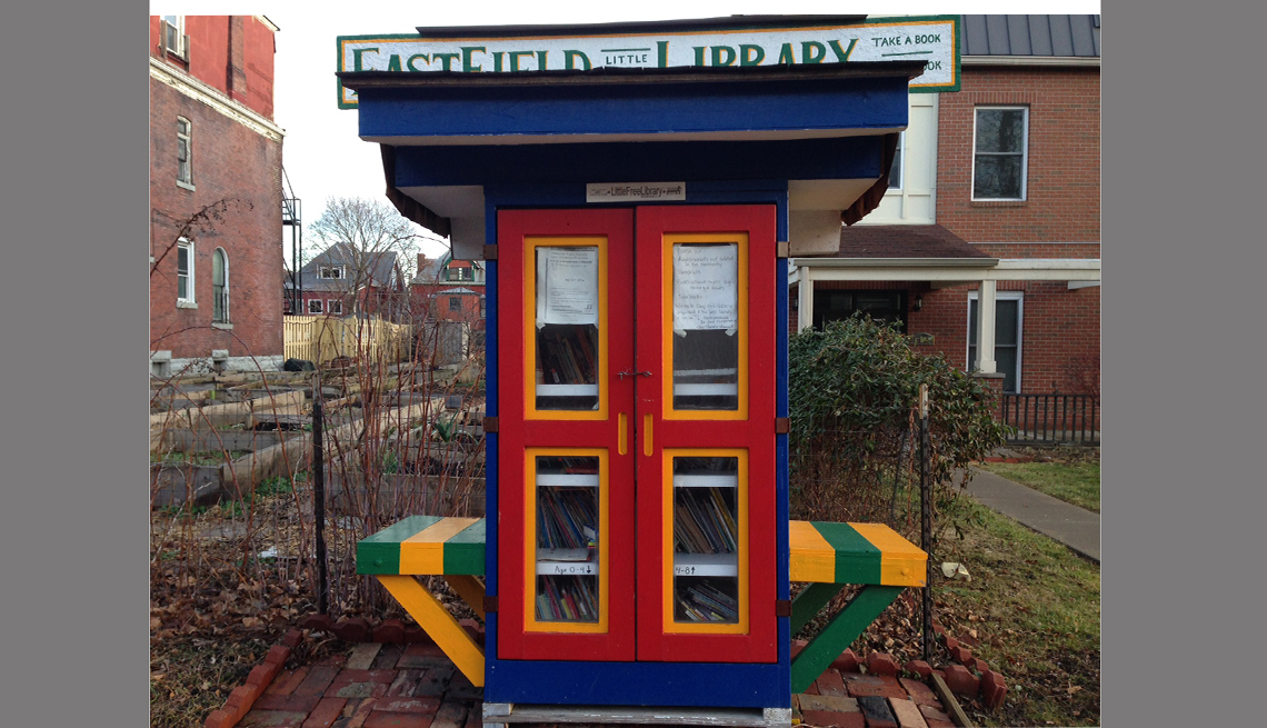 A library-sponsored Little Free Library has seating for two.