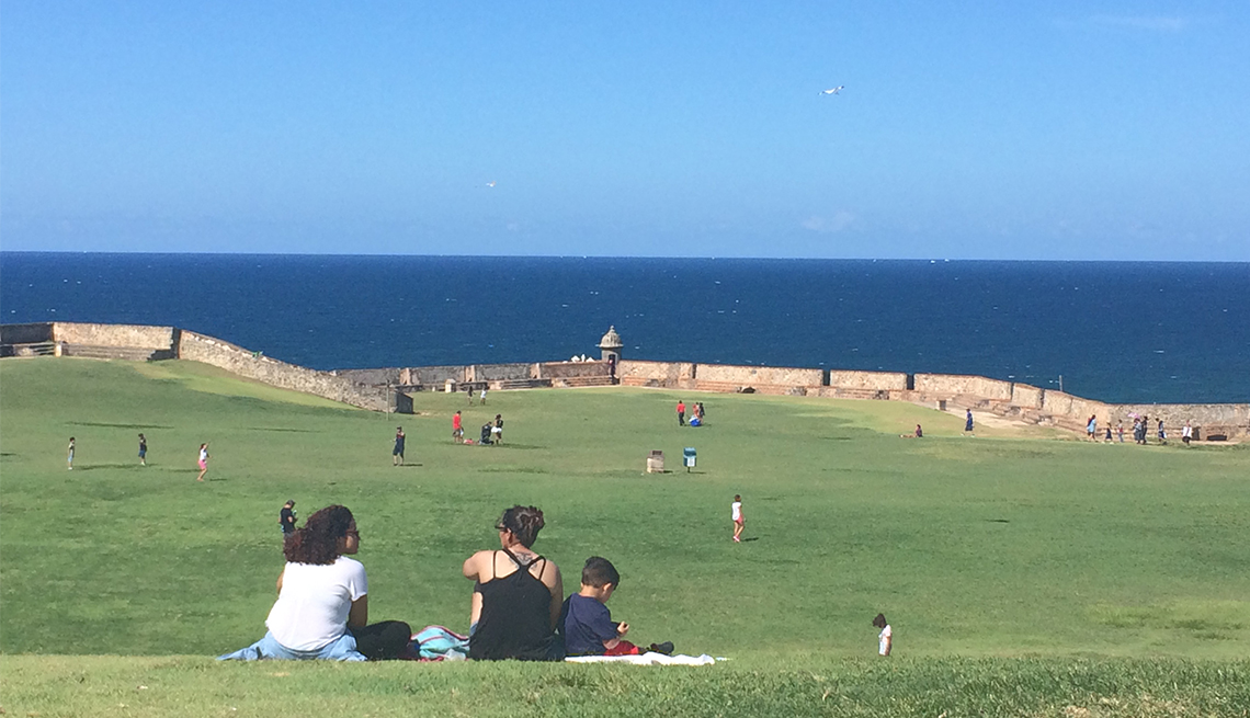 A family has a picnic on a green lawn with an ocean view in Puerto Rico