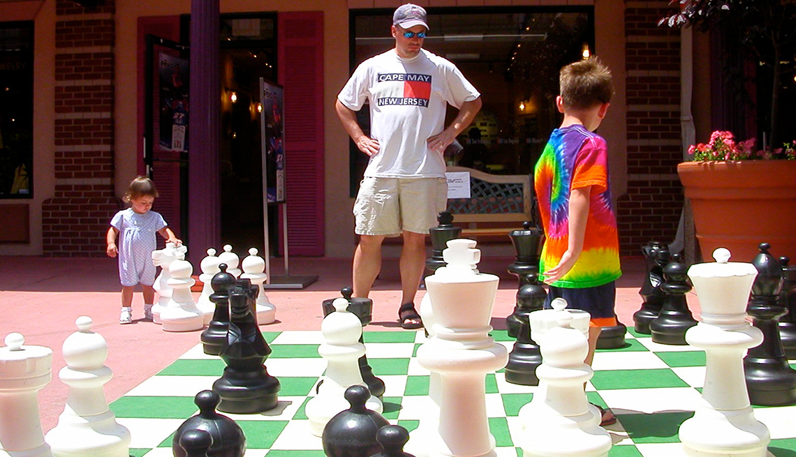 A dad and two children play giant chess in Rehoboth, Delaware