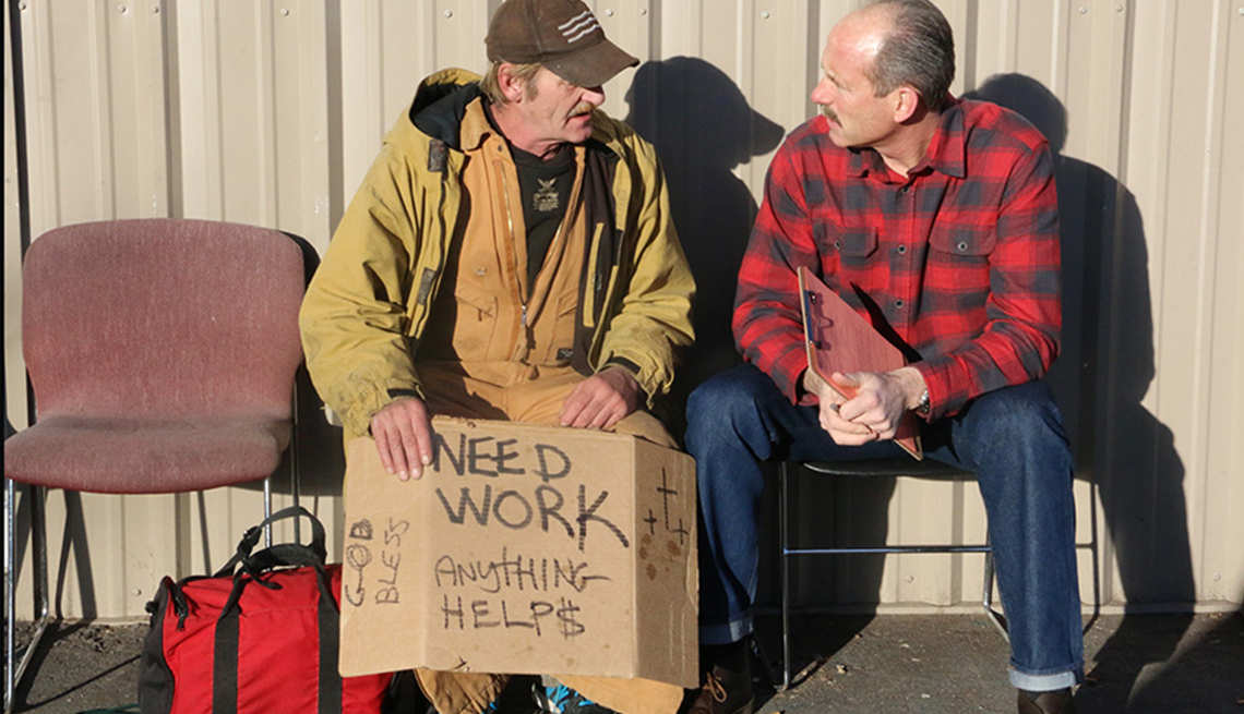 Mayor Richard Berry of Albuquerque, New Mexico, speaks with a man holding a cardboard sign that says Need Work, Anything Helps