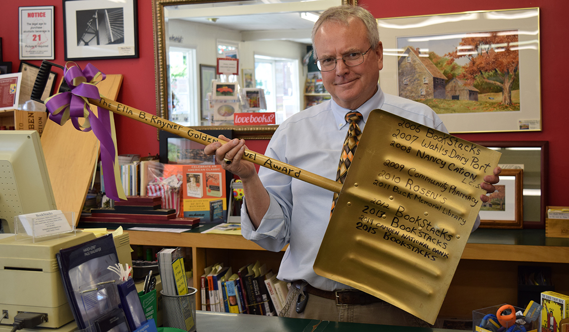 Andy Lacher, owner of BookStacks in Bucksport, Maine, displays his Golden Shovel Award for keeping his business's sidewalks clear of snow.