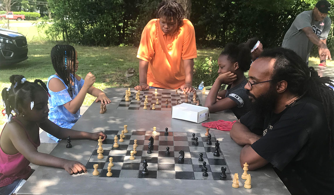 Children and adults play chess outdoors in Macon, Georgia