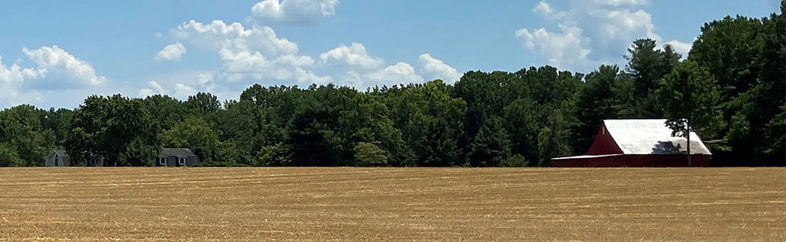 Scene of a farm field and farm house