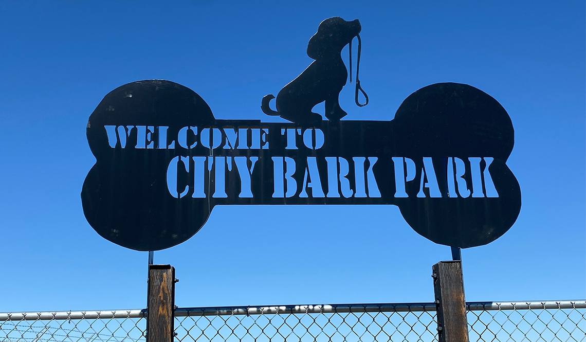 A dog-bone shaped sign that says Welcome to Cut Bark Park
