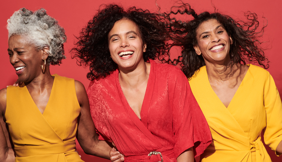 a group of three women smiling and laughing
